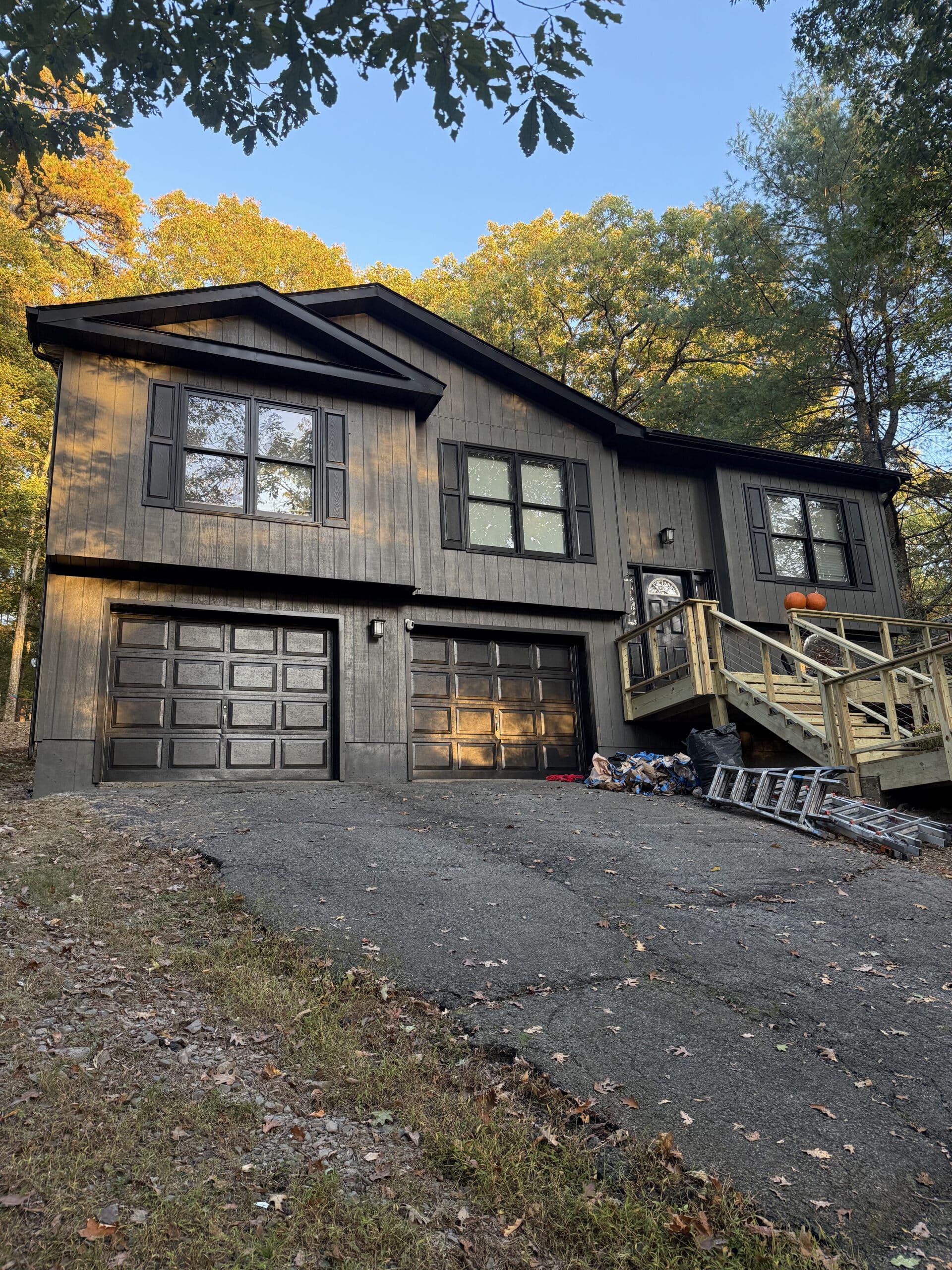 Professional exterior house painting for a stunning white brick home A beautifully painted white brick house with black accents and a lush green lawn, showcasing expert exterior painting services.